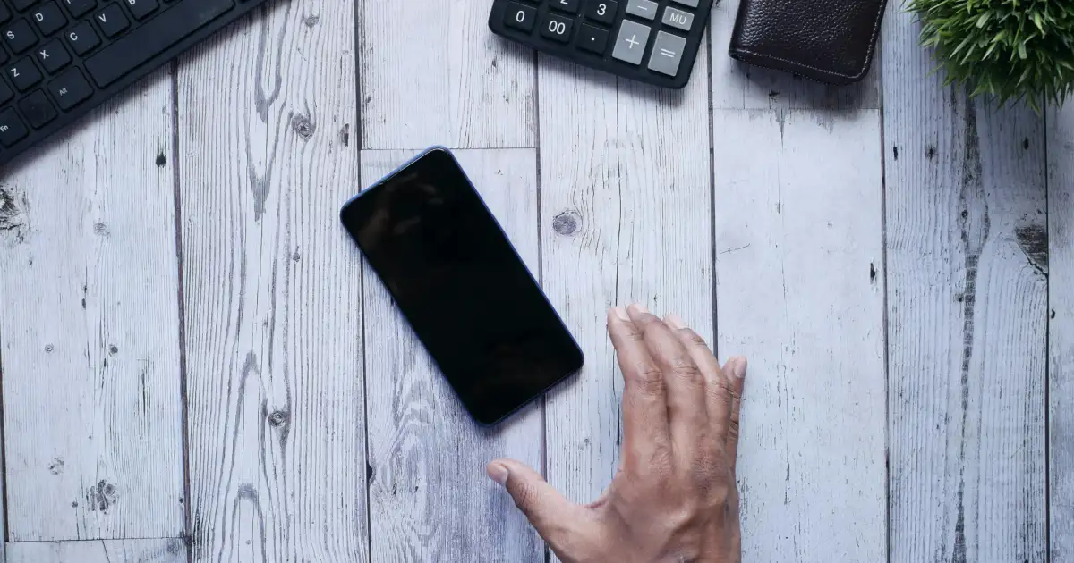 Detoks cyfrowy - telefon ekranem w dół na biurku obok notesu