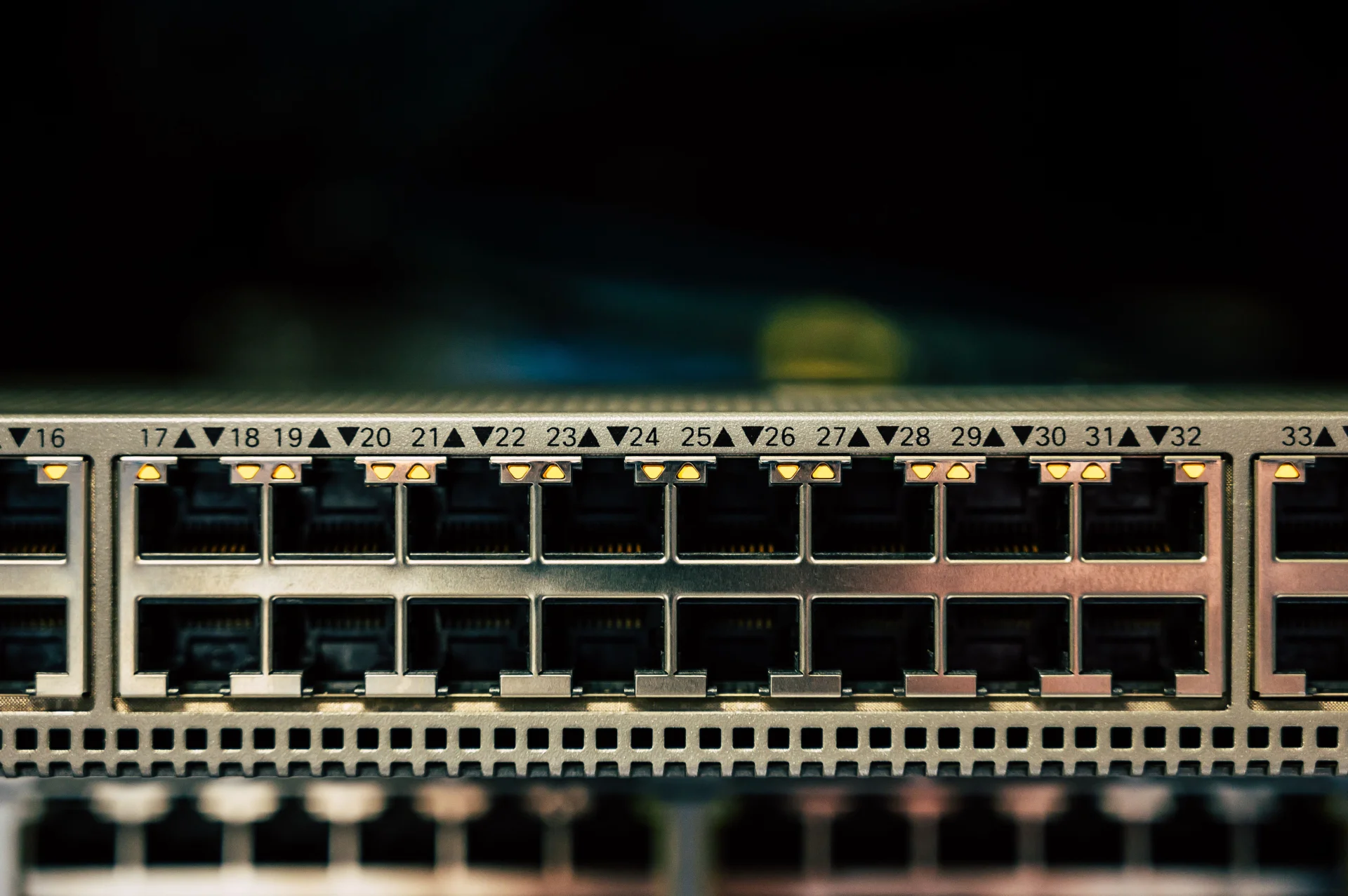 Szczegółowy widok przełącznika sieciowego z wieloma portami Ethernet i wskaźnikami LED.